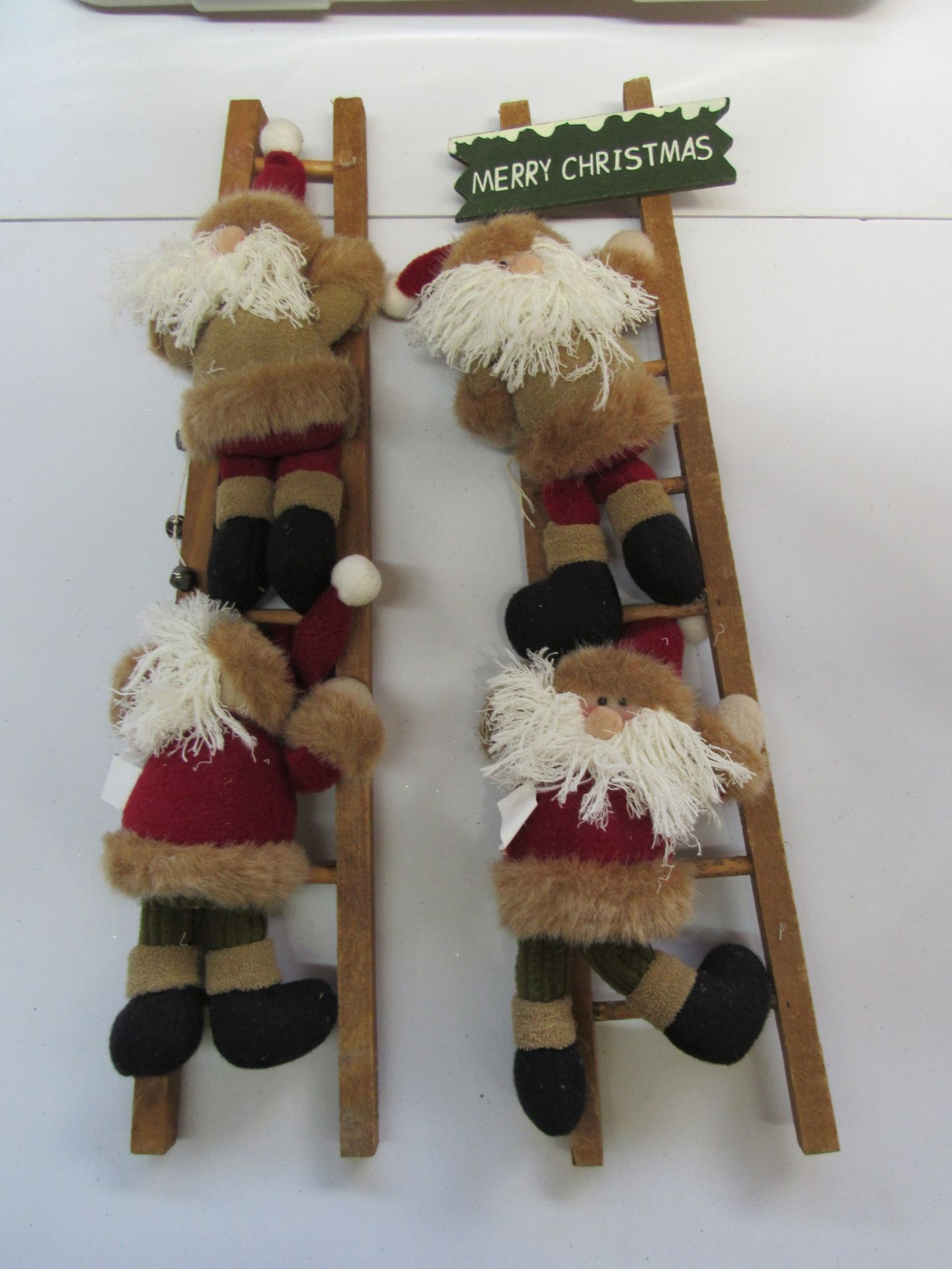 Group of stuffed Santa Clauses climbing ladders