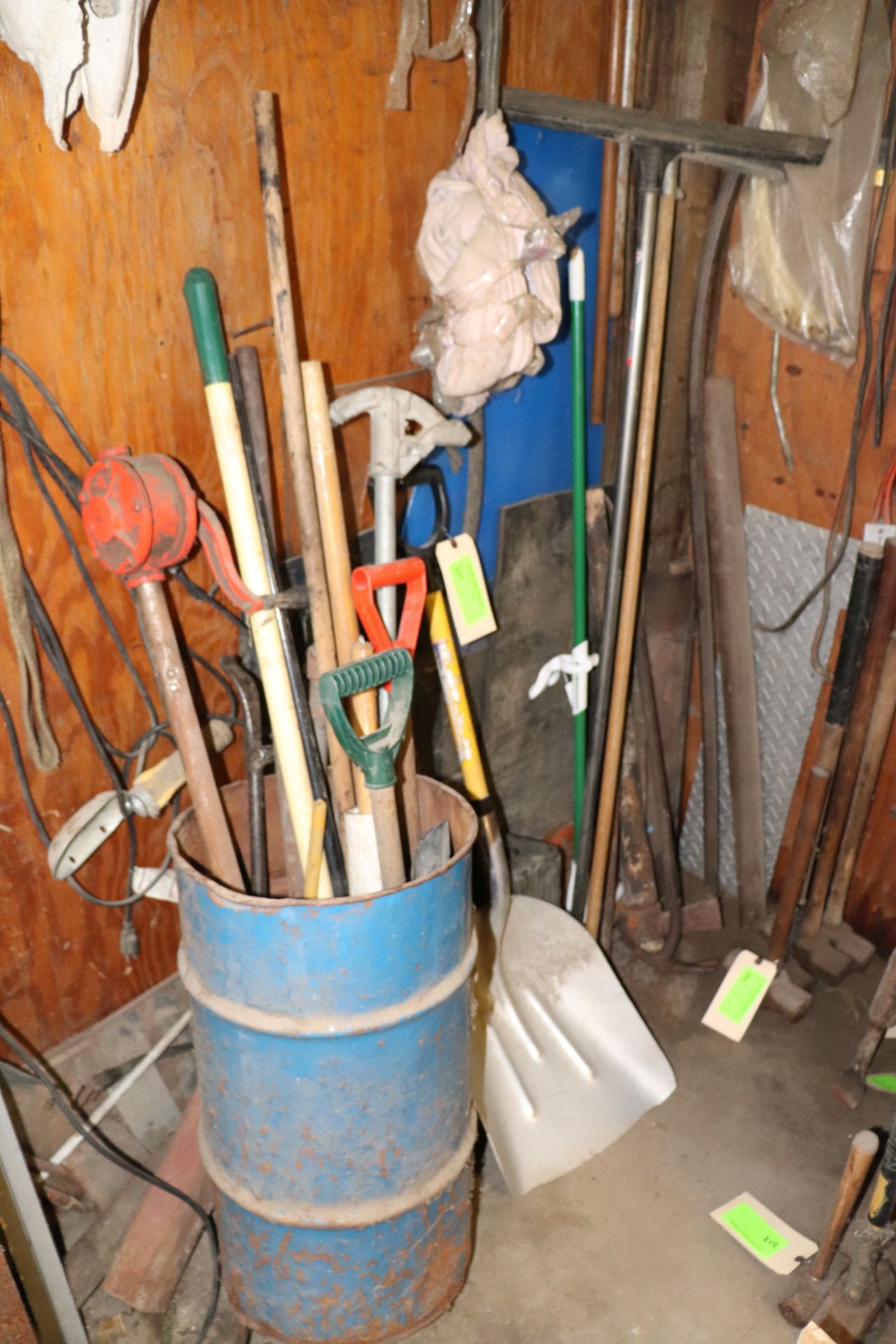 Assorted yard implements, cleaning mops, brooms, pipe bender, shovels, etc.
