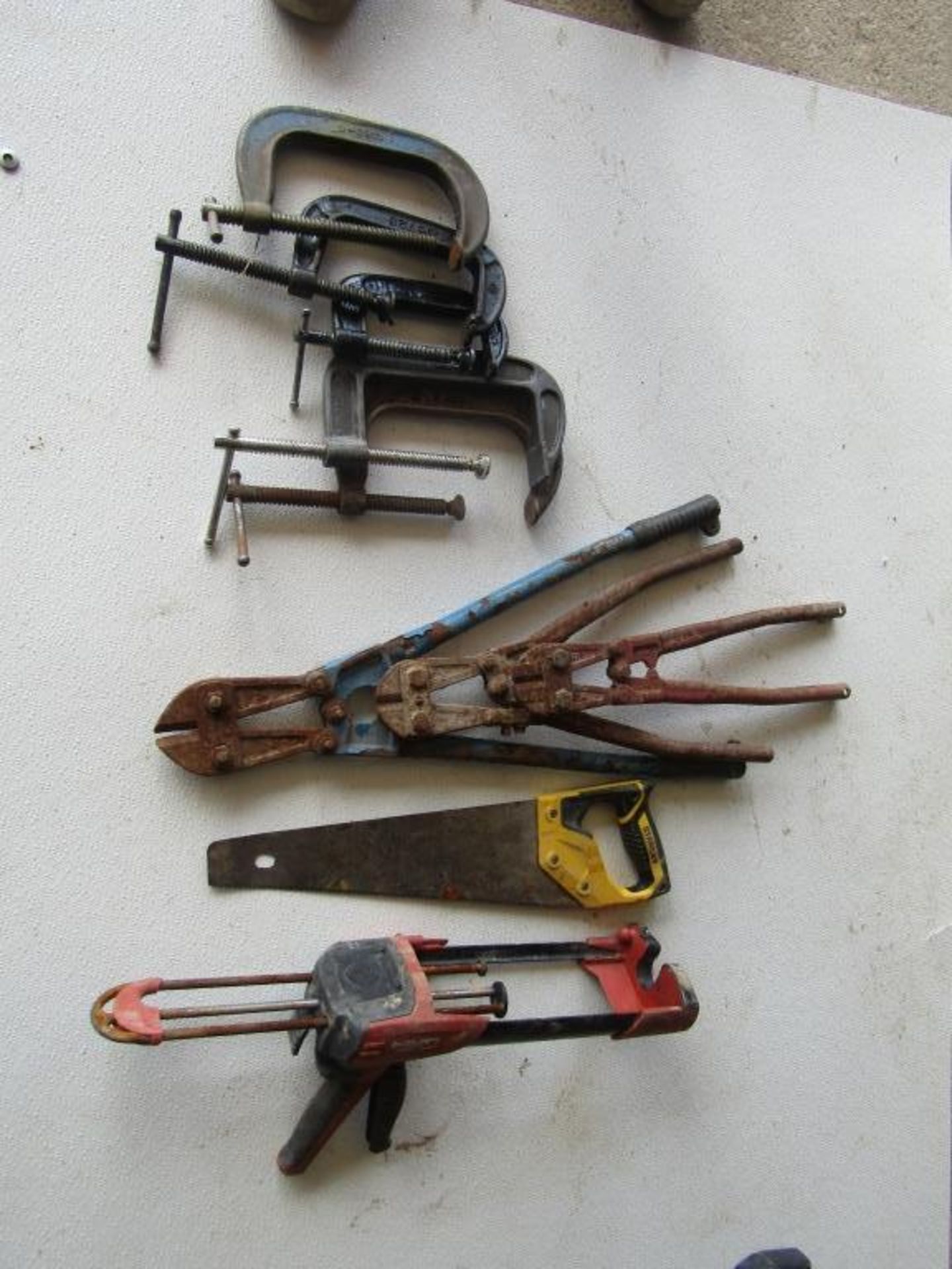 (10) Miscellaneous Tools, (5) C-Clamps, (3) Bolt Cutters, (1) Hand Saw, (1) Caulking Gun,