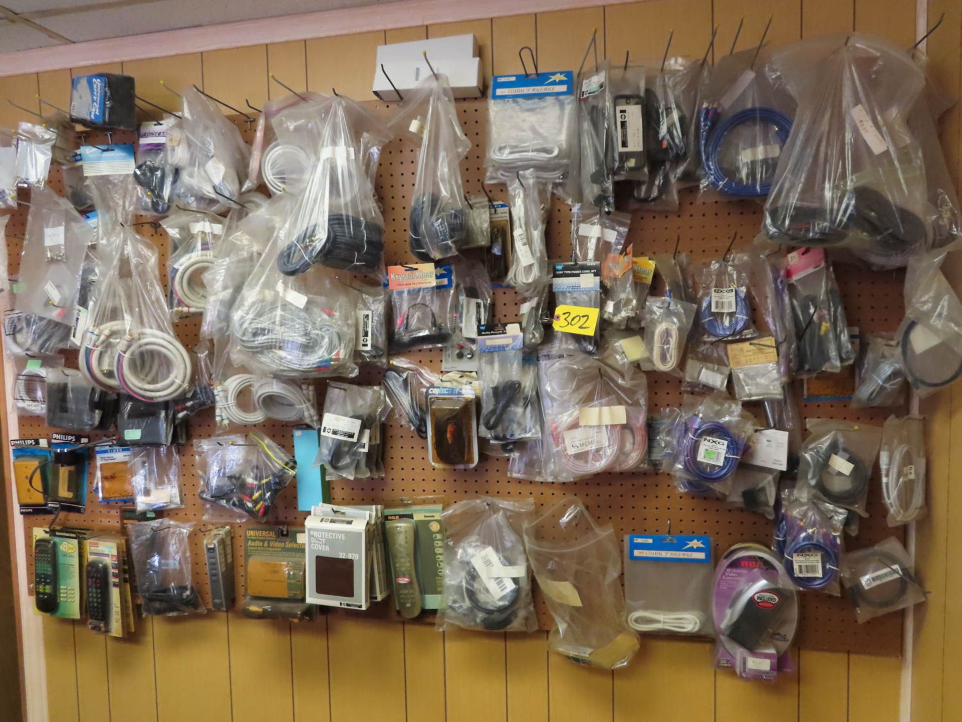 CONTENTS OF WALL INCLUDING RCA CABLES, POWER CORDS, VIDEO CONVERTERS, PHONE CABLES, REMOTES, ETC