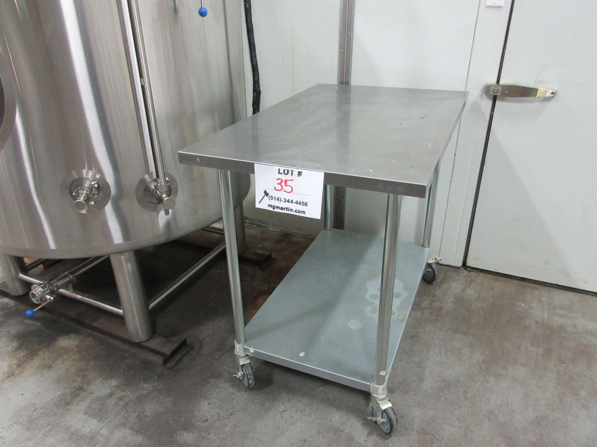 Stainless steel table 30" x 48" x 39" high (aprox) c/w wheels