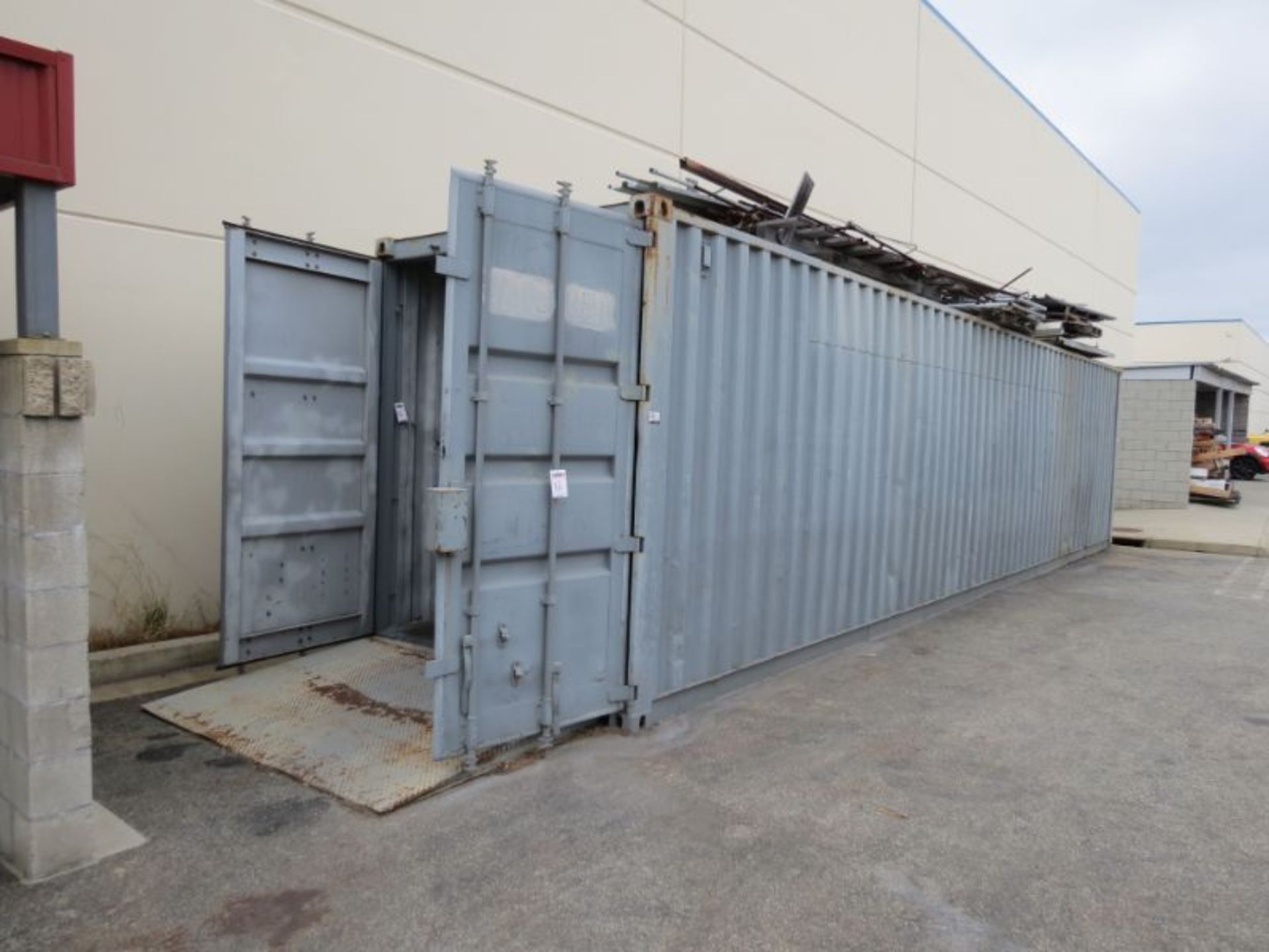 40' Storage Container w/ Loading Ramp and material on top