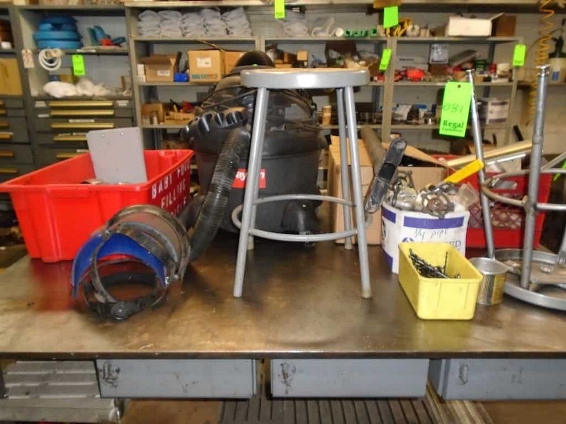 Contents of top of table ( Dayton shop vac, box of assorted valves, drills bits, stools)