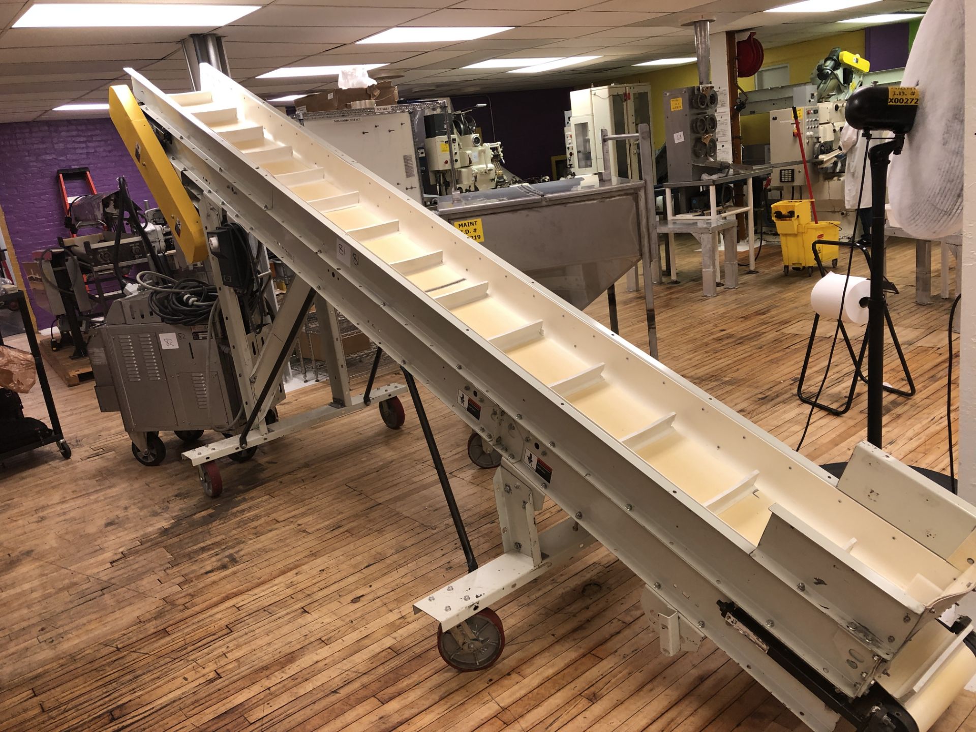 Inclined cleated conveyor 12" wide x 15-ft long with 2.5" cleats and 78" discharge height on casters