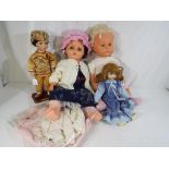 A collection of four dolls comprising two large plastic dolls and two porcelain faced collector