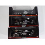 Minichamps - three 1:18 scale diecast F1 cars by Minichamps with a McLaren theme,