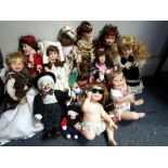 In excess of twelve ceramic faced collectors dolls to include posing babies,