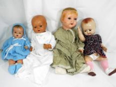 A collection of three composition dolls to include a boy doll marked to the head 133,