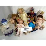A collection of in excess of 15 porcelain collector dolls to include posing babies,
