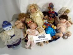 A collection of in excess of 15 porcelain collector dolls to include posing babies,