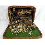 A wicker basket containing a diorama of a flower shop with displays of wicker baskets, flowers,