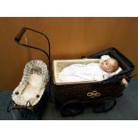Two quality reproduction doll's prams, one with wicker body, metal wheels and wooden handle,