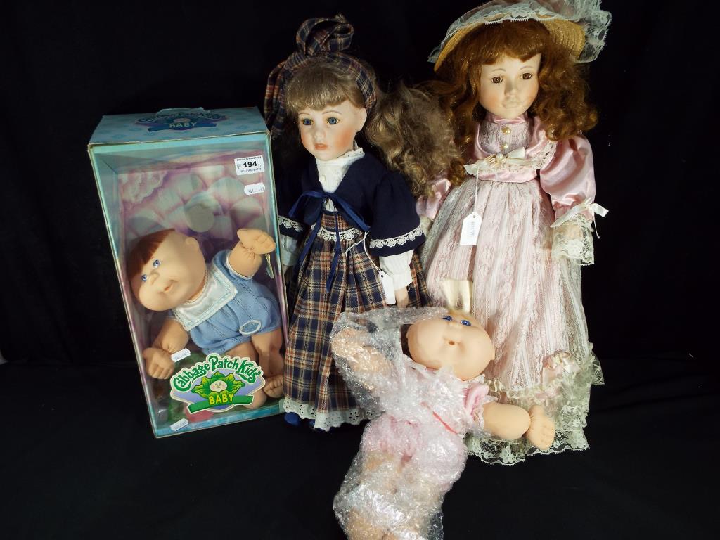 A collection of dolls to include two Cabbage Patch Kids, one boxed and two ceramic collector dolls,