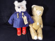 A Paddington bear, blue coat, red wellies,