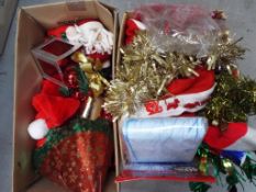 Two boxes containing a quantity of Christmas decorations and similar.