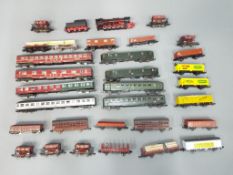 Trix, Lima & other - 30 unboxed railway wagons, coaches and a static steam locomotive.