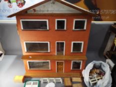 A wooden three story dolls house with accessories, approximately 75 cm x 73 cm x 41 cm.