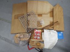 A wooden traditional dolls house kit with instructions, electric kit for lighting and accessories.