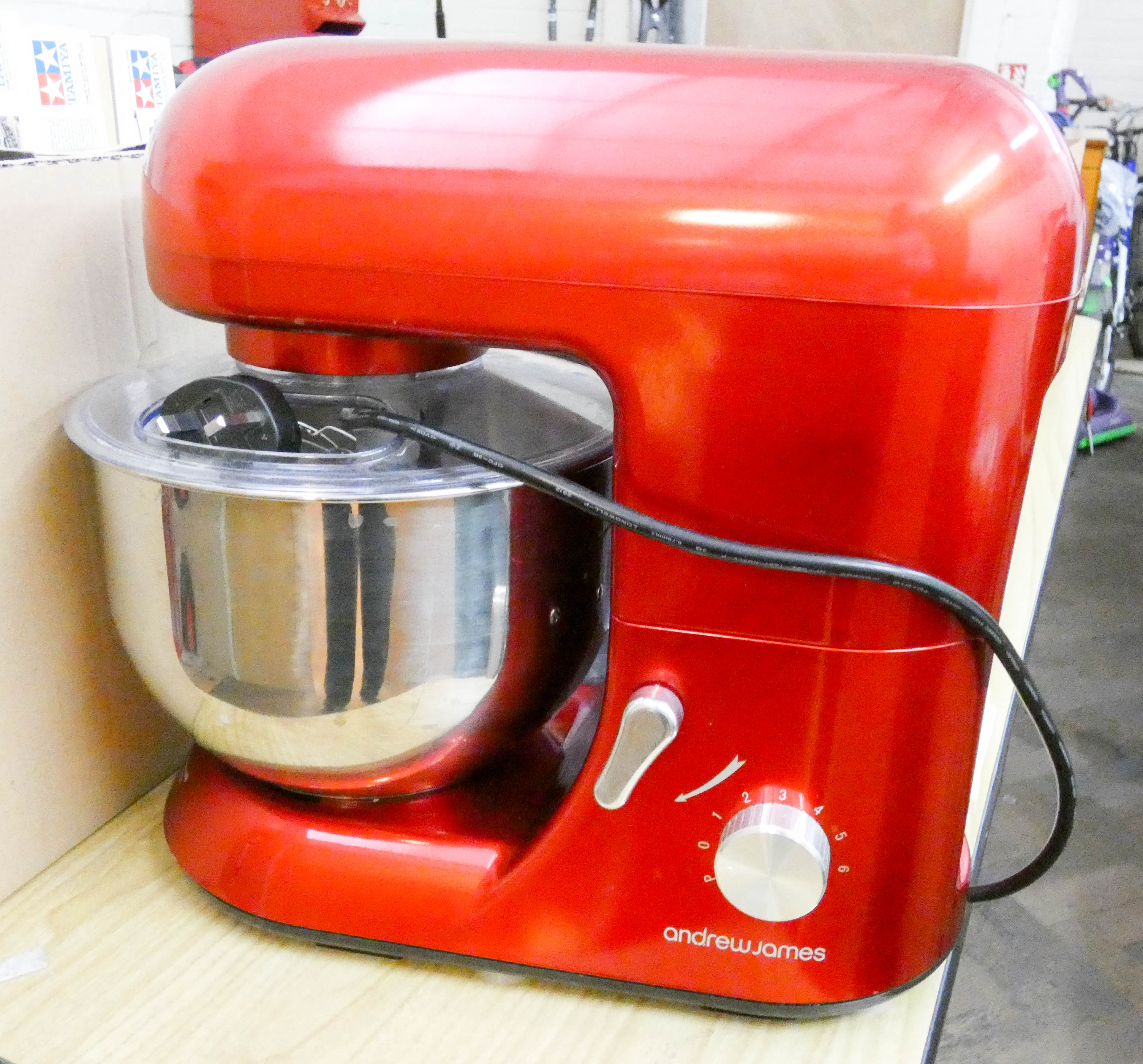 An Andrew James modern food mixer in red and chrome finish with accessories and books