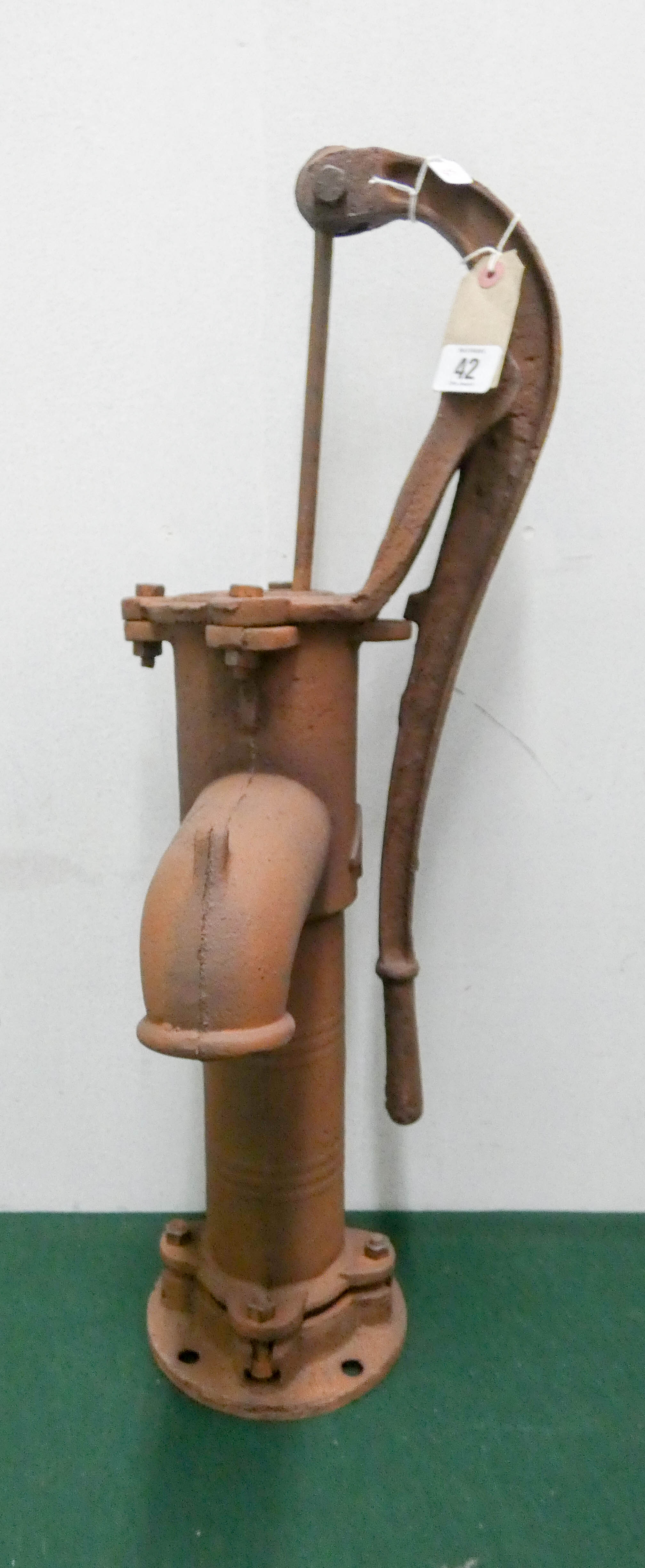 A large cast iron rusty garden pump ornament