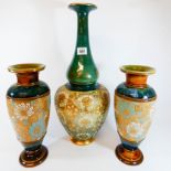 A pair of Doulton Lambeth stoneware vases decorated with turquoise and white flowers on a green