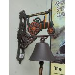 A cast iron wall hanging bell with steam engine top