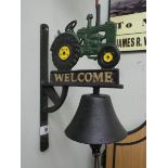 A cast iron wall hanging with tractor top and 'Welcome'