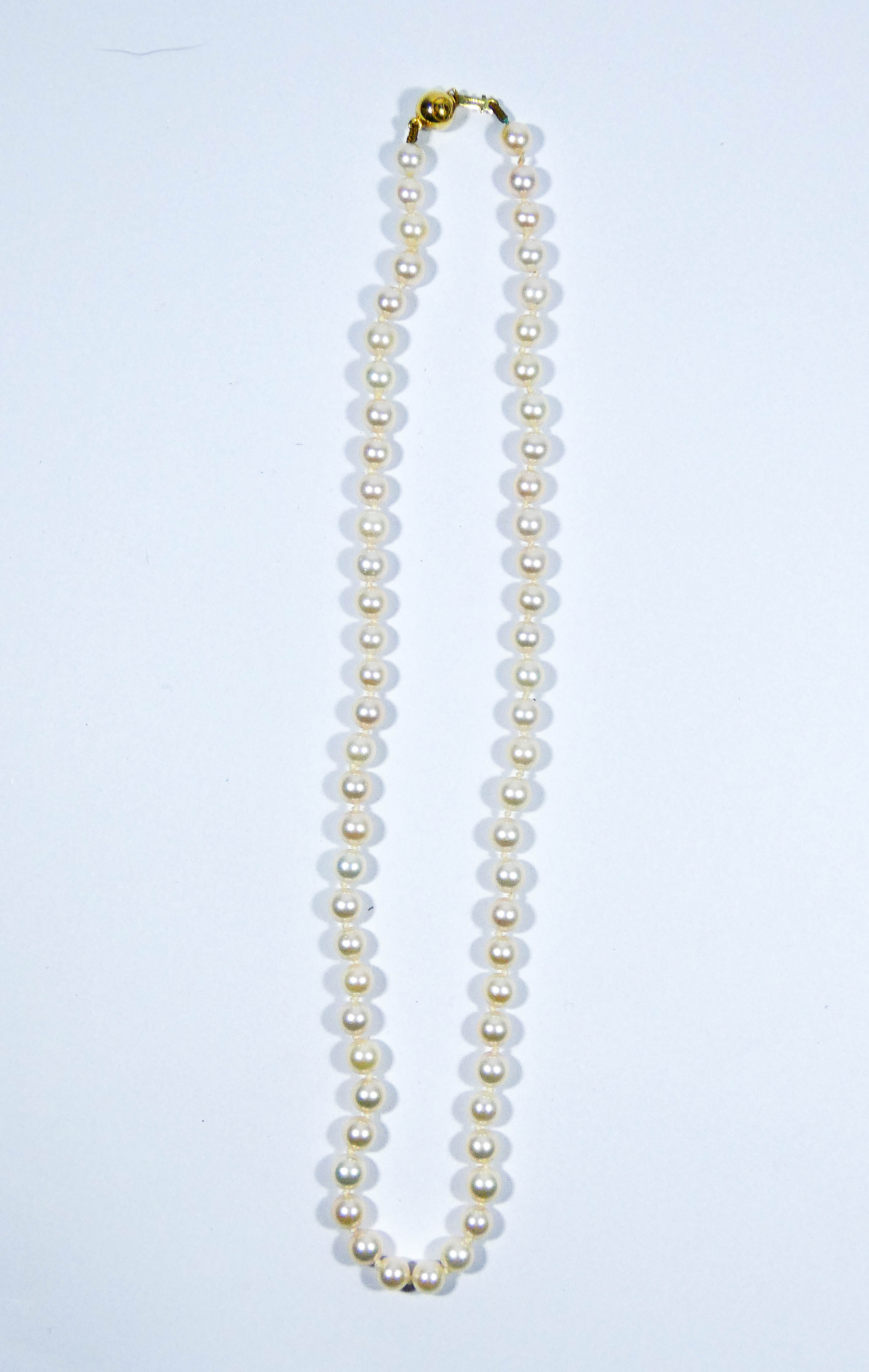 Row of uniform cultured pearls, with 18ct yellow gold bead clasp, 42 cms long.