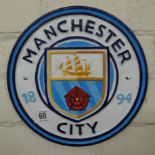 A circular Manchester City cast iron wall hanging plaque