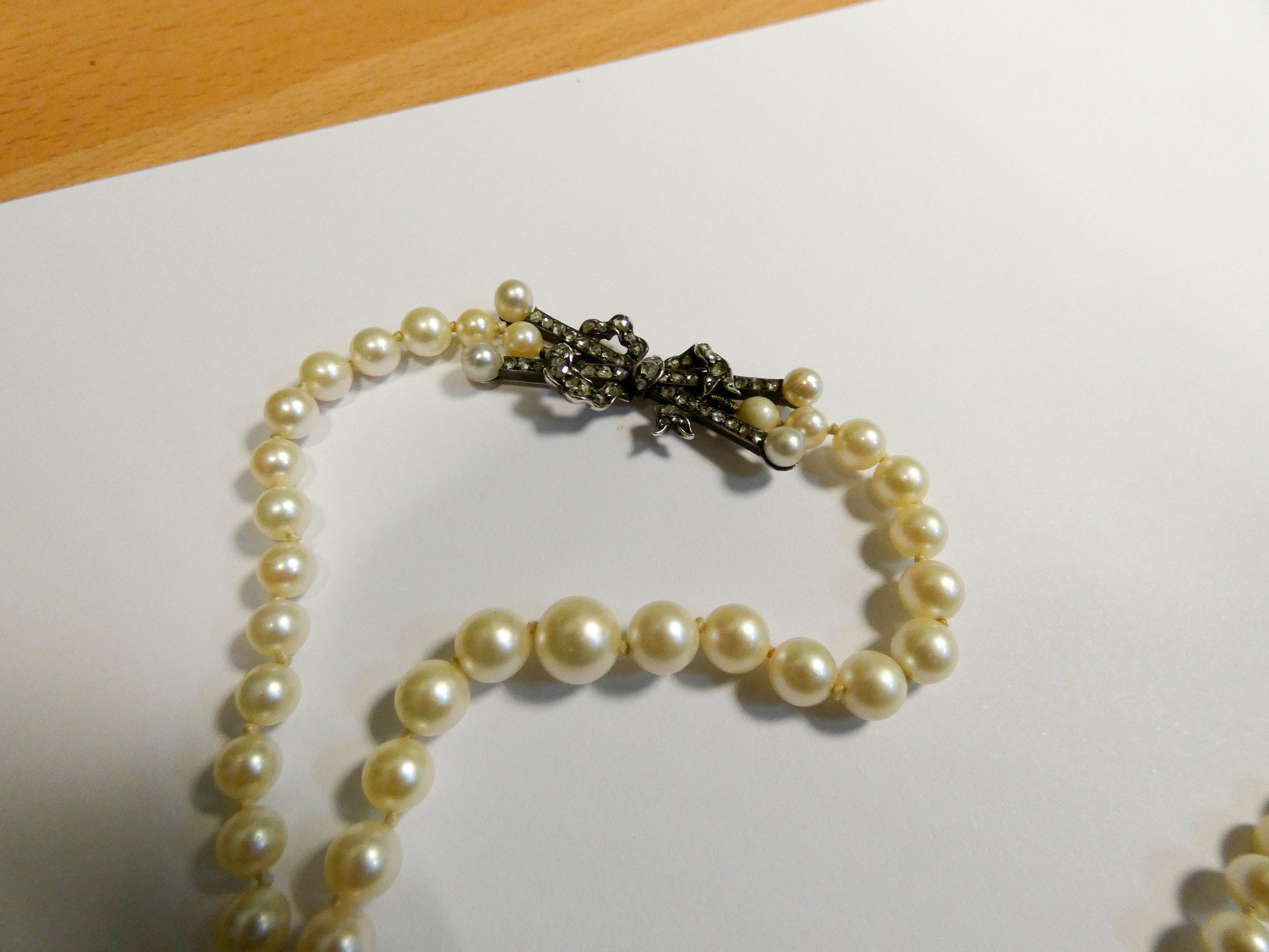 1930's graduated row of cultured pearls with stylish rose cut diamond bow set to the side. - Image 4 of 7