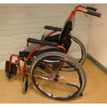 A red ultra lightweight self propelled wheelchair by Karma