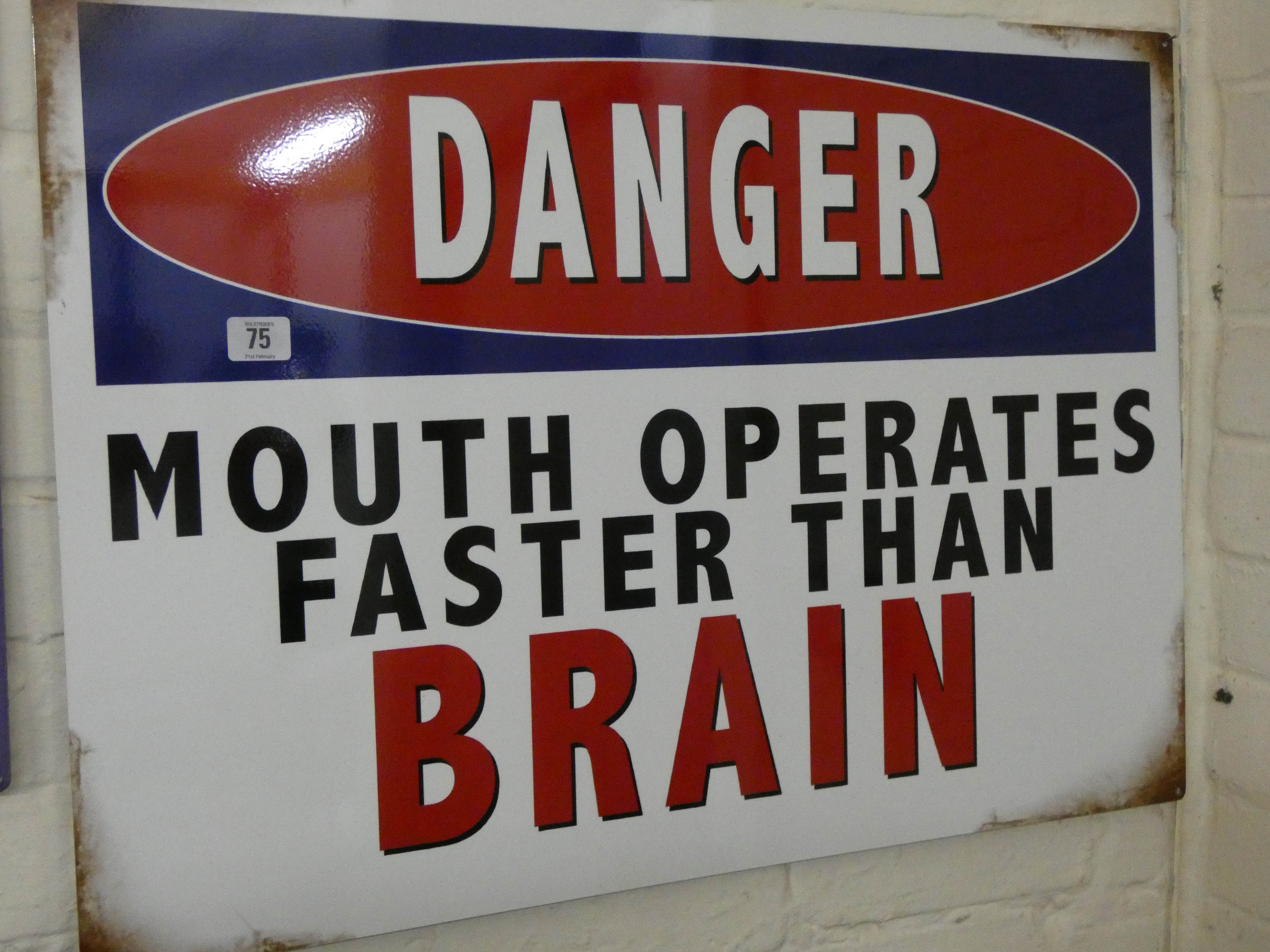 A large painted metal advertising sign 'Danger Mouth Operates Faster Than Brain'