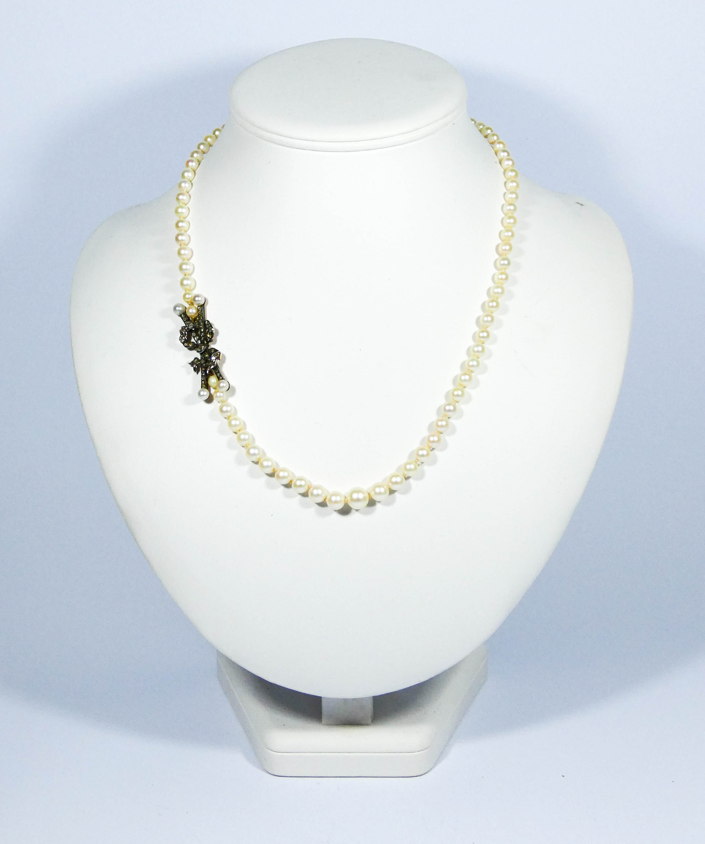 1930's graduated row of cultured pearls with stylish rose cut diamond bow set to the side.