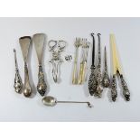 A collection of silver items to include, glove stretchers, button hooks, sugar nips,