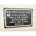 A black and white cast iron No Trespassing wall hanging sign