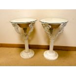 A pair of white painted iron figure decorated plant pedestals with inset plastic liner and glass