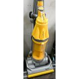 A yellow and silver Dyson upright vacuum cleaner