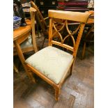 A set of four light beech dining chairs with green upholstered seats