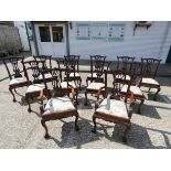 A set of Chippendale style mahogany dining room chairs standing on claw and ball feet with cream