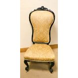 A Victorian ebonised framed prie dieu chair standing on cabriole legs with gold upholstered seat