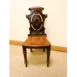 A Victorian mahogany hall chair with shaped decorative back