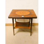 An Edwardian mahogany two tier folding top card table,
