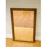 A bevelled wall mirror in rope style gilt frame