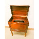 A Georgian style mahogany lift top drinks cabinet standing on square tapered legs with partly