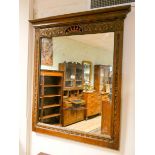 A large wall mirror in a carved oak frame,