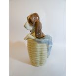 A Lladro porcelain figurine of a puppy in a linen basket