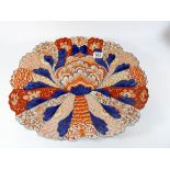A large shaped Imari charger decorated with floral designs in a typical palate,