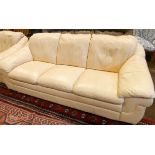A three piece lounge suite in cream leather comprising three seater settee,