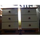 A pair of modern pine and cream three drawer bedside chests