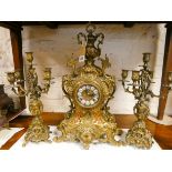 A French three piece decorative brass clock garniture comprising of striking clock and a pair of